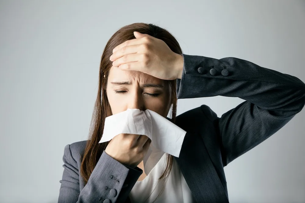 副鼻腔炎でお悩みの女性が鼻をかんでいる画像